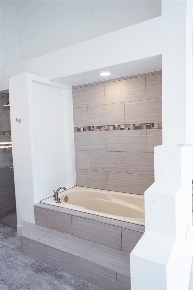 bathroom featuring tile patterned flooring and tiled tub