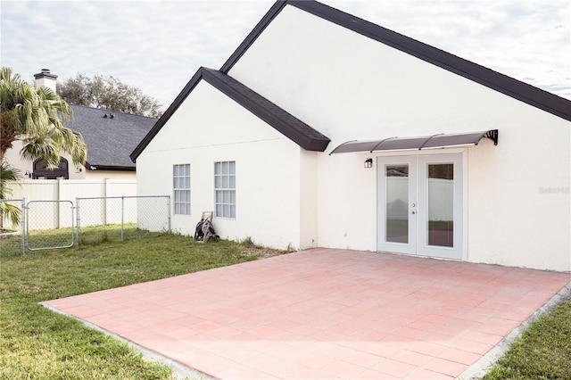 rear view of house with a yard, a patio area, and french doors