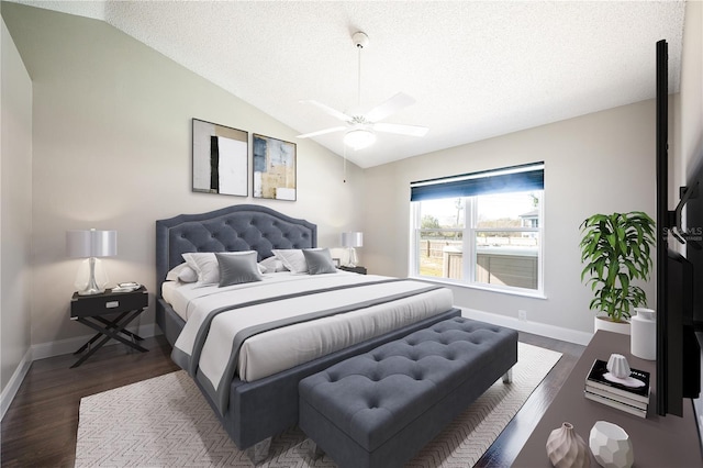 bedroom with ceiling fan, vaulted ceiling, dark hardwood / wood-style floors, and a textured ceiling