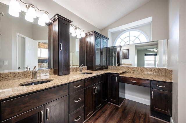 bathroom featuring lofted ceiling, vanity, wood-type flooring, and a textured ceiling