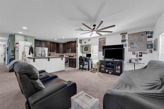 living room with ceiling fan and light colored carpet