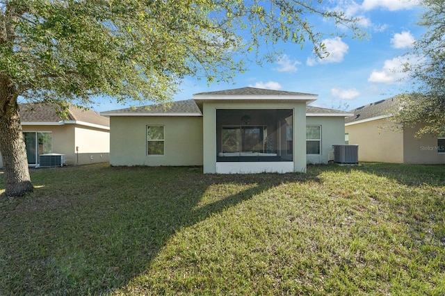 rear view of property featuring a sunroom, a yard, and central AC