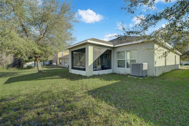 back of house with a sunroom, central AC unit, and a lawn