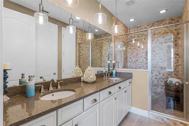 bathroom with vanity and a shower with door