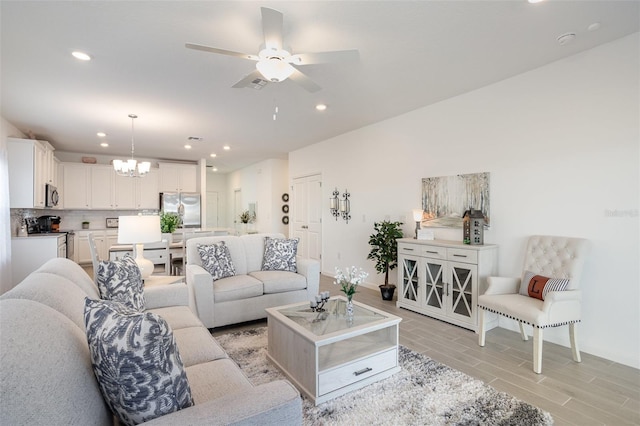 living room featuring ceiling fan with notable chandelier