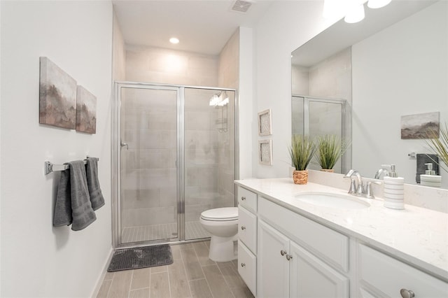 bathroom with walk in shower, vanity, and toilet