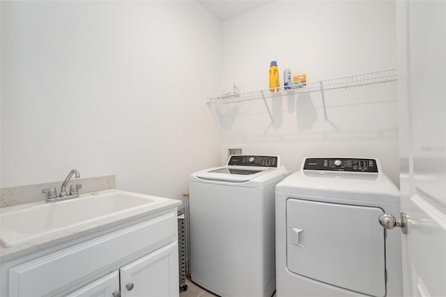 clothes washing area with sink, cabinets, and washing machine and clothes dryer