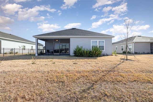 back of house with a sunroom and a yard