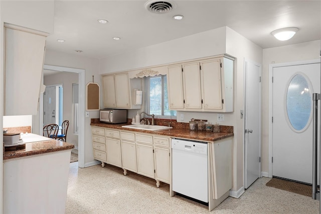 kitchen with white dishwasher, sink, and cream cabinetry