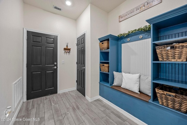 mudroom with a textured ceiling and light hardwood / wood-style flooring