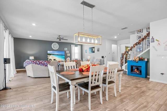 dining space with ceiling fan, light hardwood / wood-style flooring, and a textured ceiling