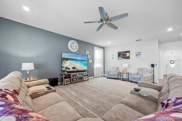 carpeted living room featuring ceiling fan and a textured ceiling