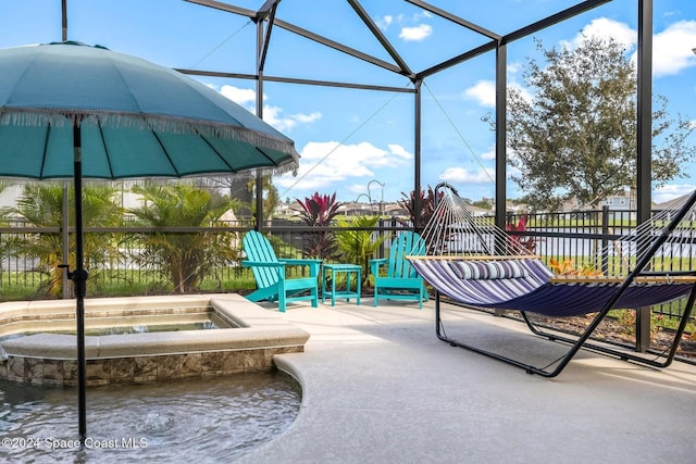 view of patio / terrace with an in ground hot tub, a water view, and glass enclosure