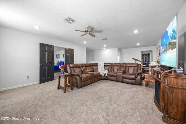 carpeted living room with ceiling fan and a textured ceiling