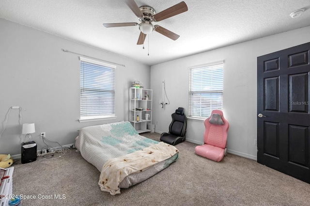 bedroom featuring a textured ceiling, ceiling fan, and carpet