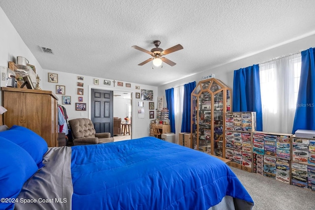 bedroom featuring ceiling fan, carpet floors, and a textured ceiling