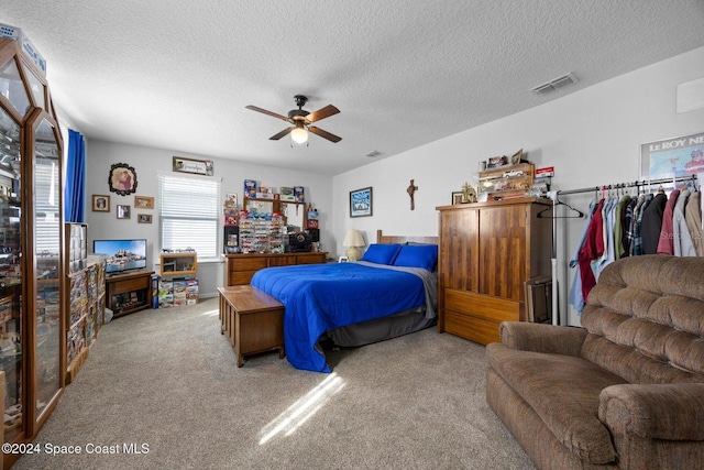 carpeted bedroom with a textured ceiling and ceiling fan