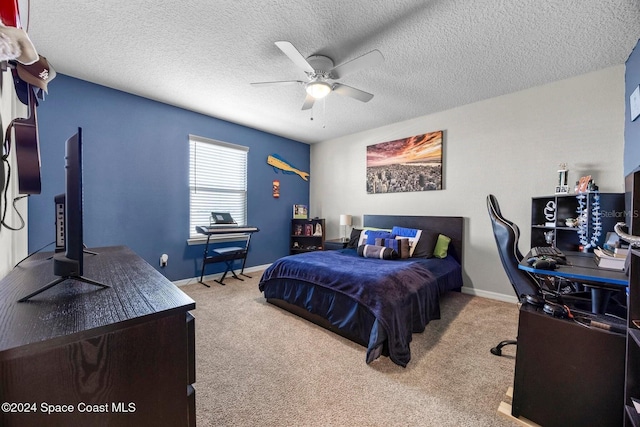 bedroom featuring ceiling fan, light colored carpet, and a textured ceiling