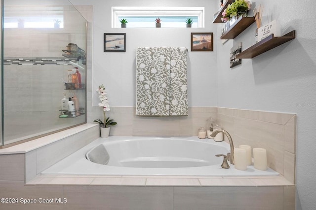 bathroom with a healthy amount of sunlight and tiled tub