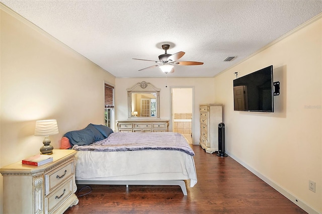 bedroom featuring dark hardwood / wood-style floors, a textured ceiling, ceiling fan, and ensuite bath