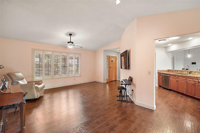 living area featuring lofted ceiling, sink, dark wood-type flooring, and ceiling fan