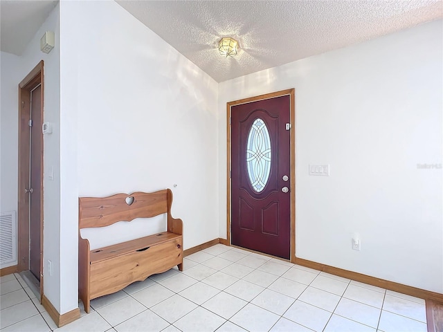 entrance foyer featuring light tile patterned floors and a textured ceiling