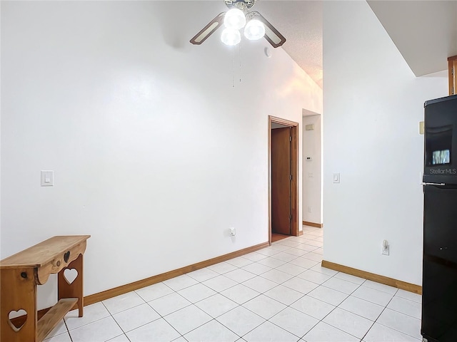 tiled spare room featuring lofted ceiling and ceiling fan