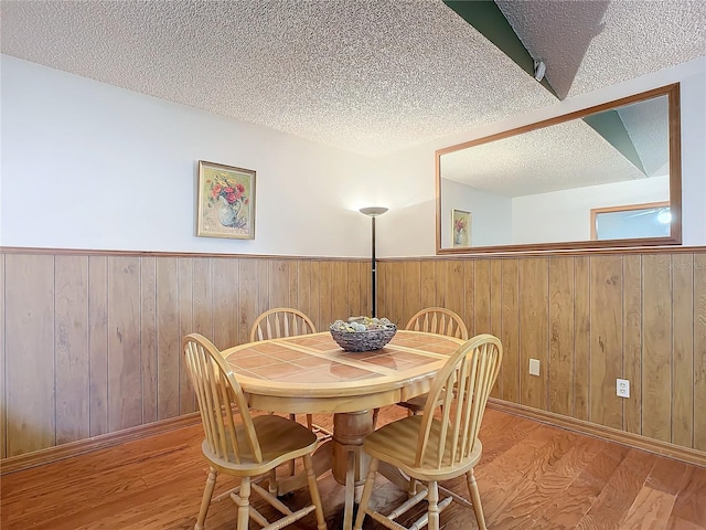 dining area with light hardwood / wood-style flooring and a textured ceiling