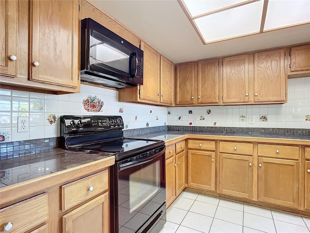 kitchen featuring light tile patterned floors, decorative backsplash, and black appliances