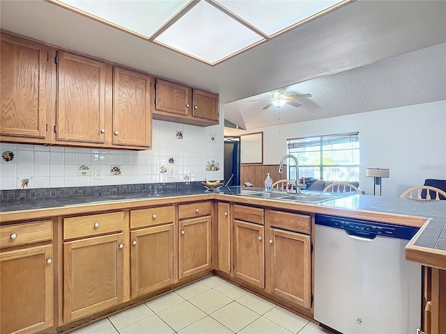 kitchen featuring ceiling fan, stainless steel dishwasher, sink, and backsplash