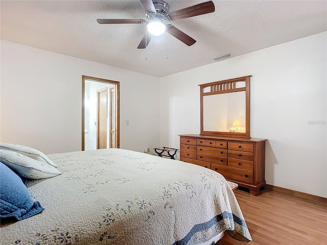 bedroom with wood-type flooring, a textured ceiling, and ceiling fan