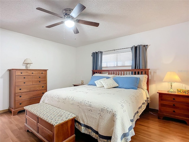 bedroom with hardwood / wood-style floors, a textured ceiling, and ceiling fan