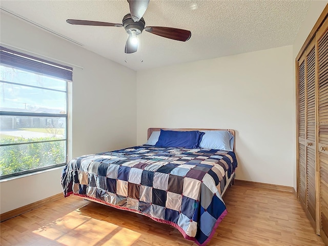 bedroom with light hardwood / wood-style flooring, a closet, and ceiling fan