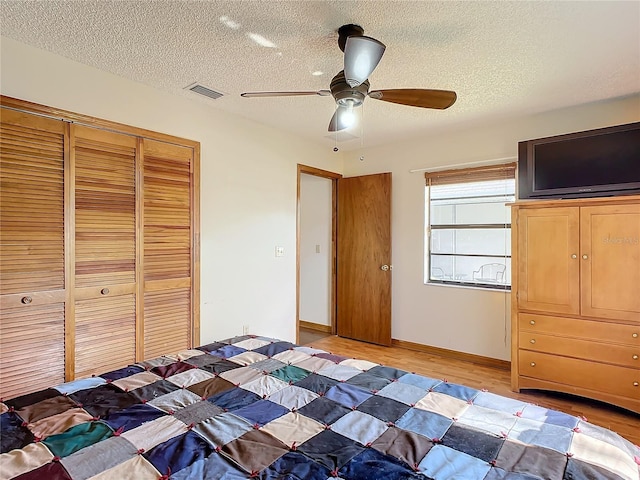 unfurnished bedroom with ceiling fan, wood-type flooring, a closet, and a textured ceiling