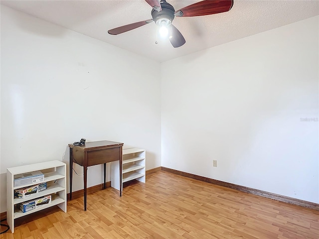 home office featuring a textured ceiling, light hardwood / wood-style flooring, and ceiling fan