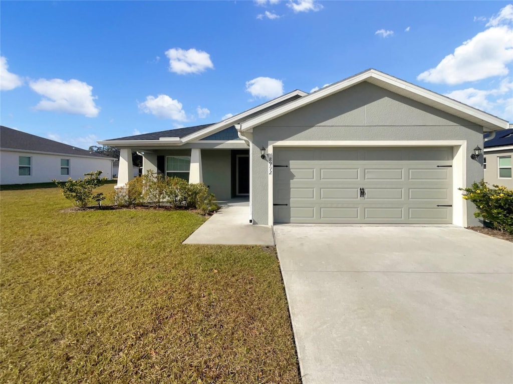 ranch-style home featuring a garage and a front yard