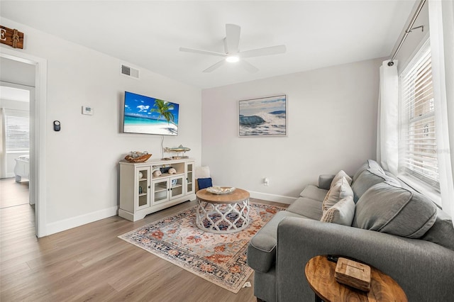 living room with ceiling fan and light wood-type flooring