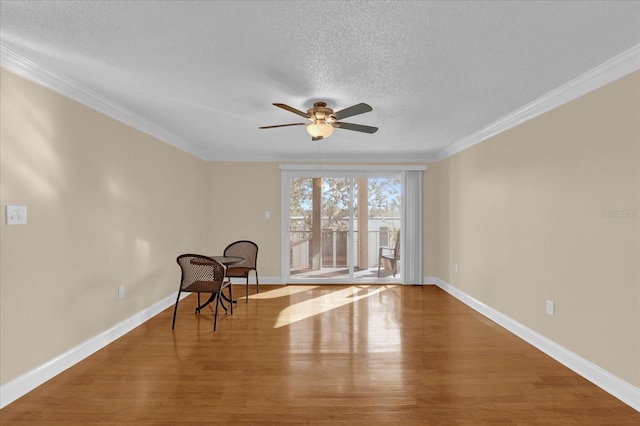 living area featuring crown molding, ceiling fan, hardwood / wood-style floors, and a textured ceiling