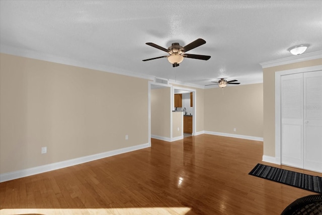 unfurnished living room featuring crown molding, hardwood / wood-style floors, ceiling fan, and a textured ceiling