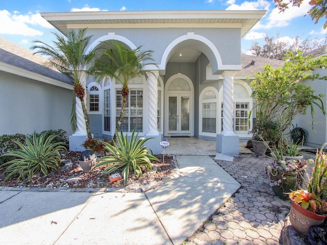 view of exterior entry featuring french doors and a patio area