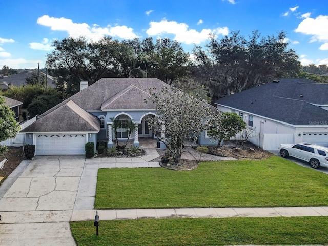 single story home featuring a garage and a front lawn