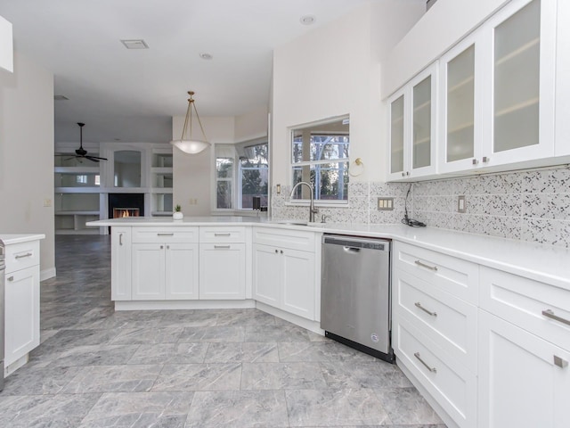 kitchen with white cabinetry, dishwasher, kitchen peninsula, pendant lighting, and backsplash