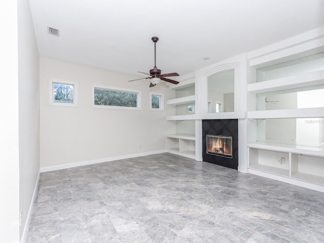 unfurnished living room with built in features and ceiling fan