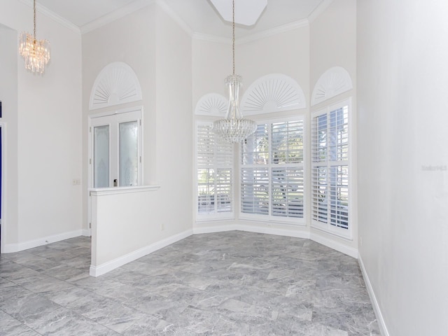 spare room with crown molding, a towering ceiling, and an inviting chandelier