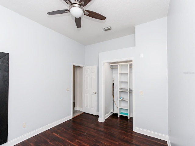 unfurnished bedroom featuring dark hardwood / wood-style flooring, ceiling fan, and a closet