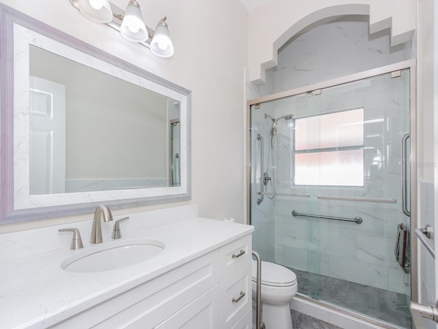 bathroom featuring vanity, toilet, and walk in shower