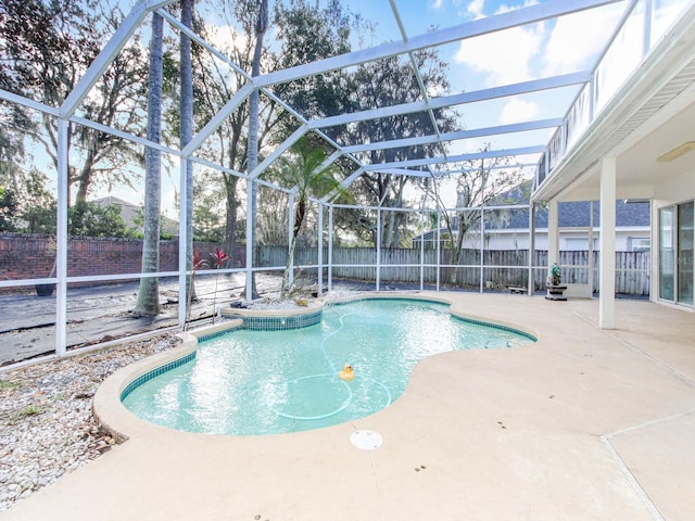 view of pool with glass enclosure and a patio area