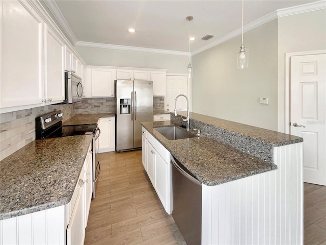 kitchen featuring white cabinetry, appliances with stainless steel finishes, sink, and an island with sink