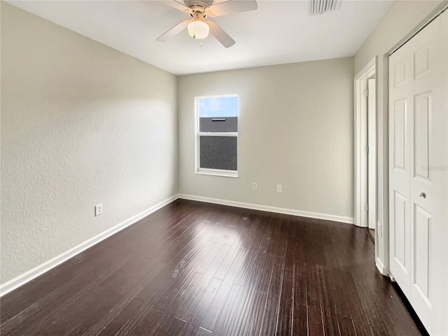 unfurnished bedroom with dark hardwood / wood-style floors, ceiling fan, and a closet