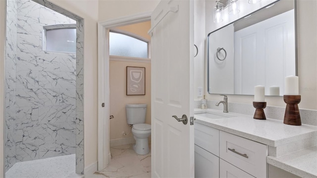 bathroom with vanity, toilet, and tiled shower